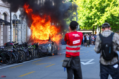 Anti-G7 protest turns violent as demonstrators torch Tesla and smash UN office windows